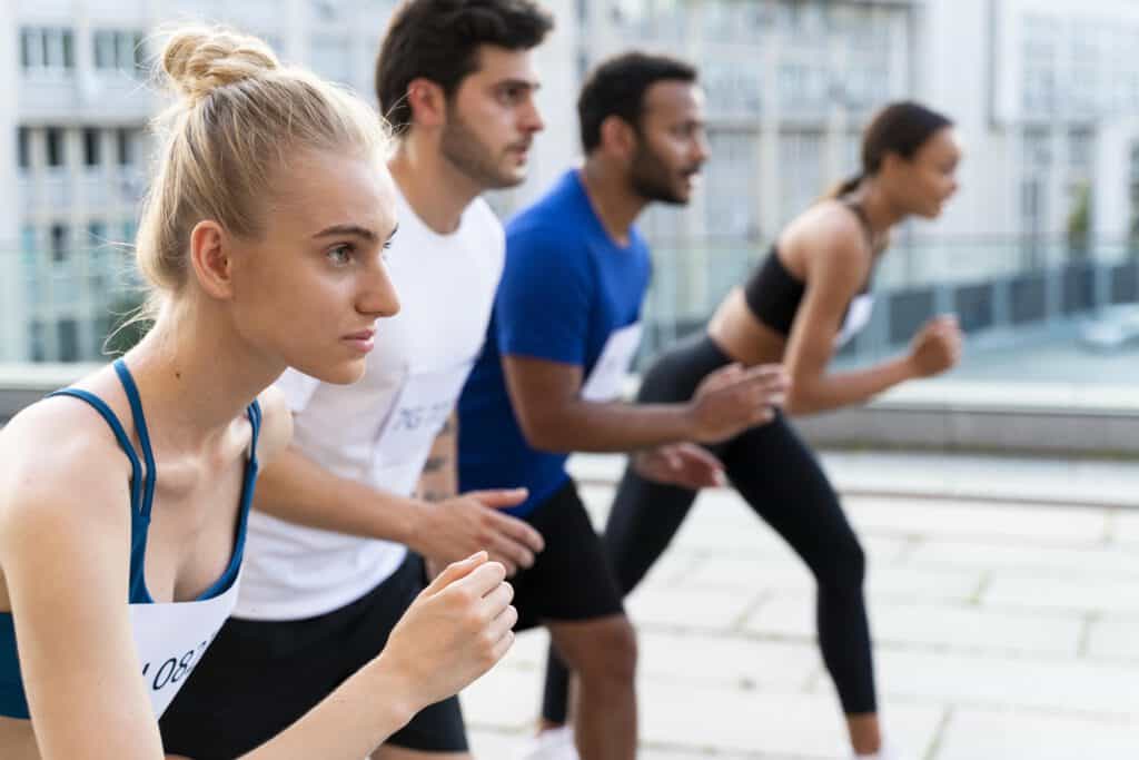 Vier Personen in Sportklamotten, die bereitstehen zum Loslaufen.